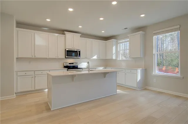 a kitchen with sink a microwave and cabinets