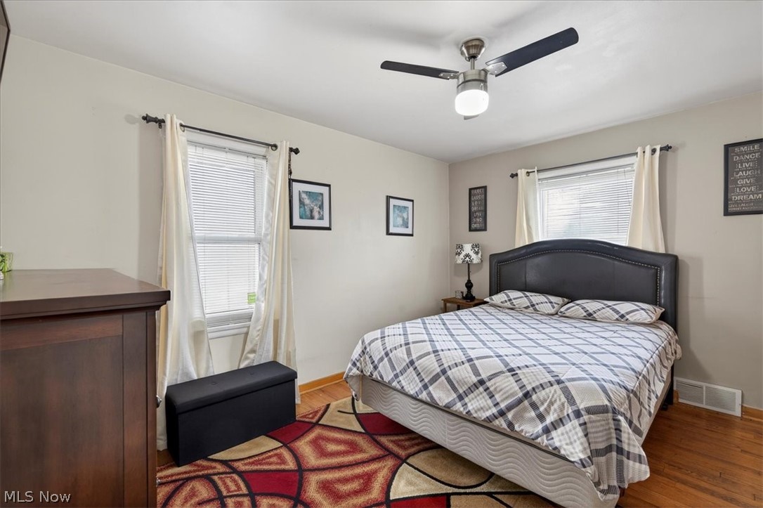 17282 McCracken Road Maple Heights, OH 44137 - Photo 11 of 26 First floor bedroom featuring wood finished floors, a ceiling fan, and multiple windows