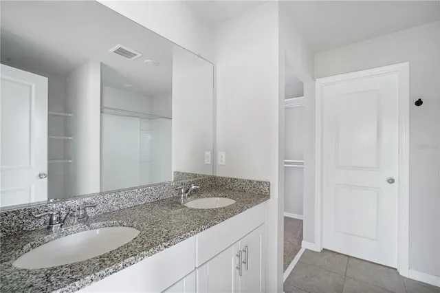 a bathroom with a granite countertop sink and a mirror