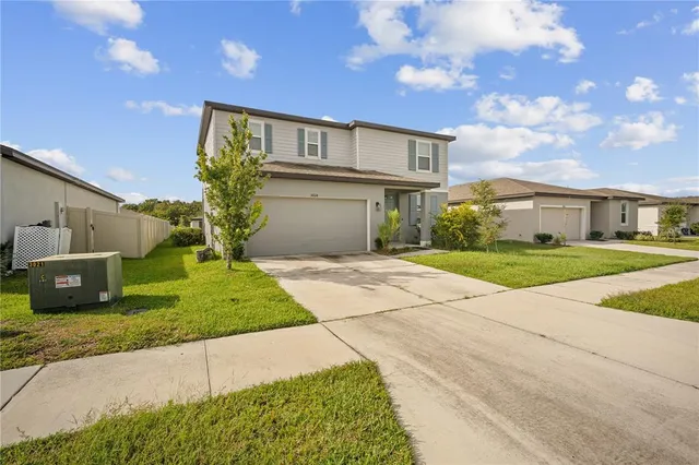 a front view of a house with a yard and a garage