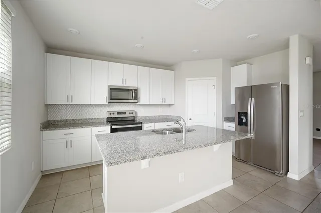 a kitchen with granite countertop white cabinets and stainless steel appliances