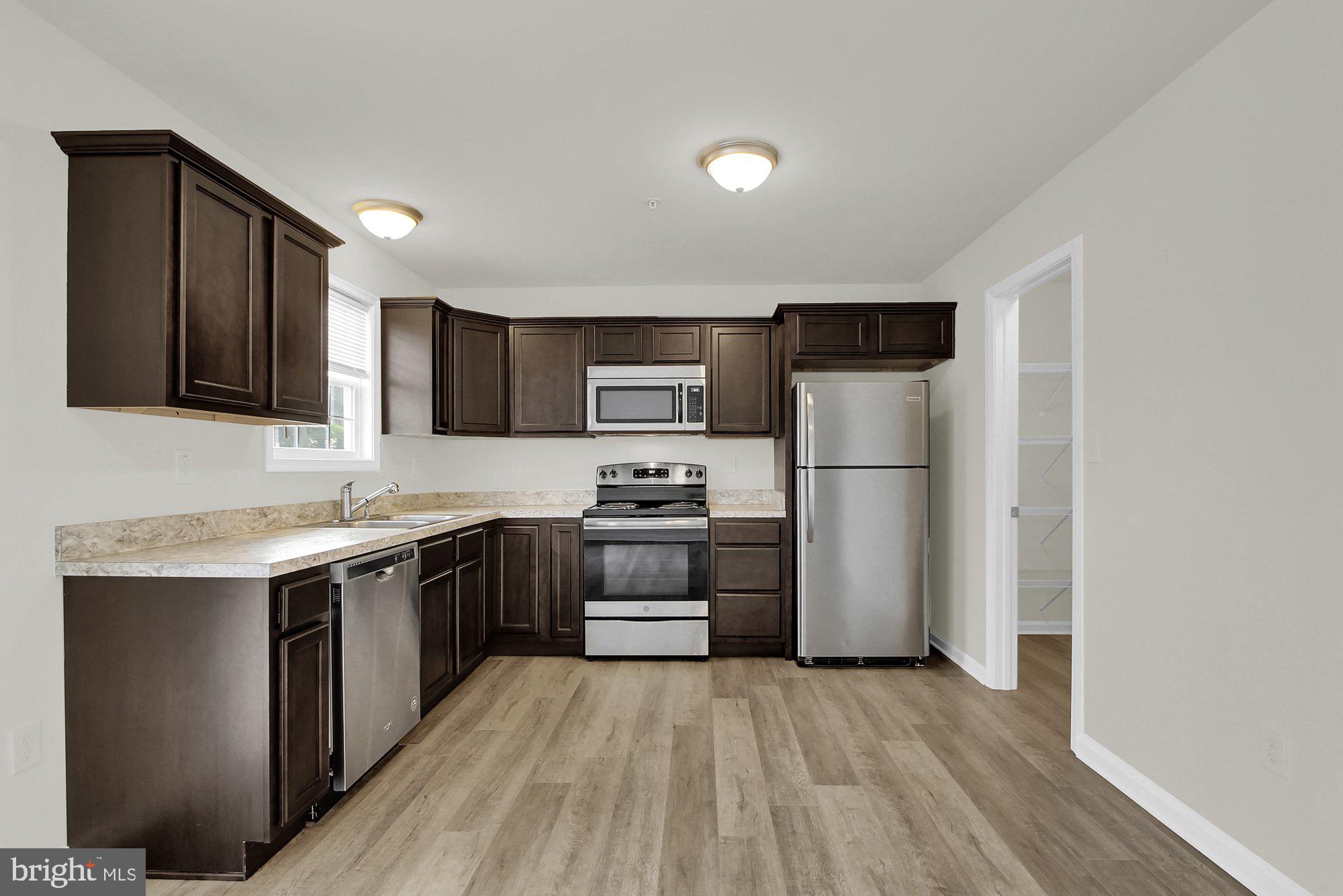 51 Overlook Dr., Unit J Hanover, PA 17331 - Photo 2 of 13 a kitchen with stainless steel appliances granite countertop white cabinets a sink a stove a refrigerator and a microwave