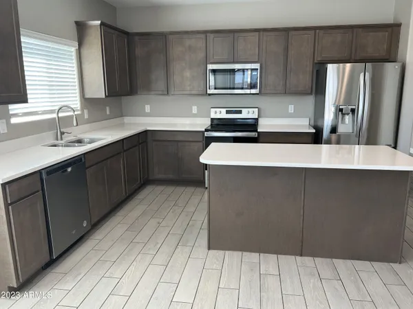 a kitchen with stainless steel appliances a refrigerator sink and microwave