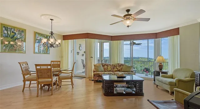a living room with furniture kitchen view and a chandelier