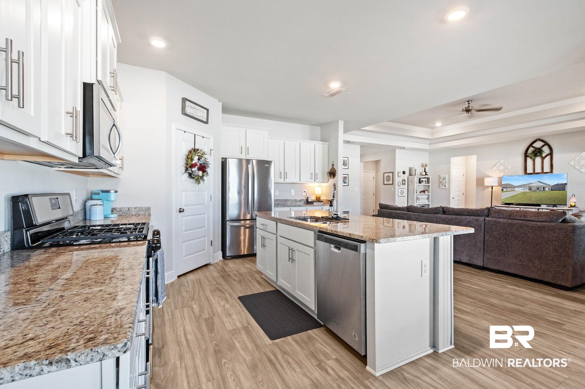24939 Spectacular Bid Loop Daphne, AL 36526 - Photo 38 of 38 Kitchen with stainless steel appliances, white cabinetry, light wood-style flooring, open floor plan, and light stone counters