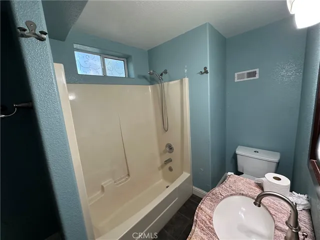 a white toilet sitting next to a shower