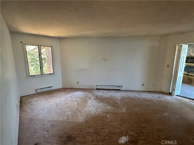 a view of empty room with wooden floor and fireplace