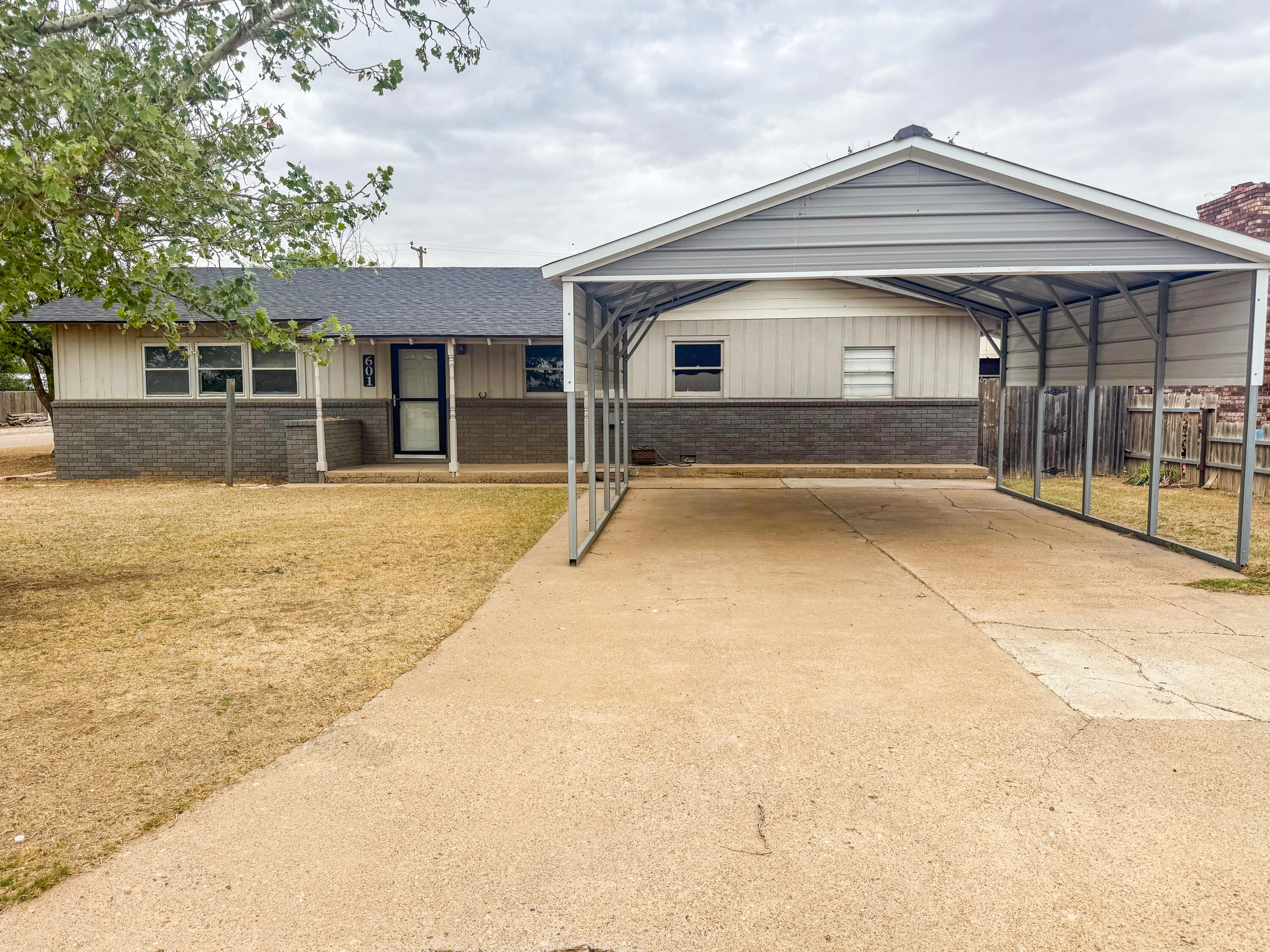 601 Northeast 3rd Street Earth, TX 79031 - Photo 2 of 8 a front view of a house with a yard and garage