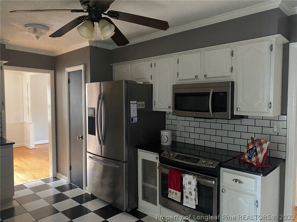 1811 Lyon Road Fayetteville, NC 28303 - Photo 13 of 27 a kitchen with stainless steel appliances granite countertop a refrigerator a stove a sink and a microwave