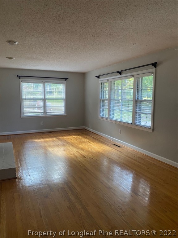 1811 Lyon Road Fayetteville, NC 28303 - Photo 9 of 27 an empty room with wooden floor and windows