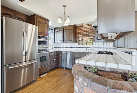 a kitchen with stainless steel appliances granite countertop a refrigerator and a stove