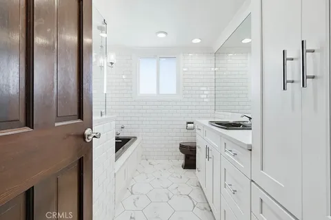 a view of a kitchen with white cabinets