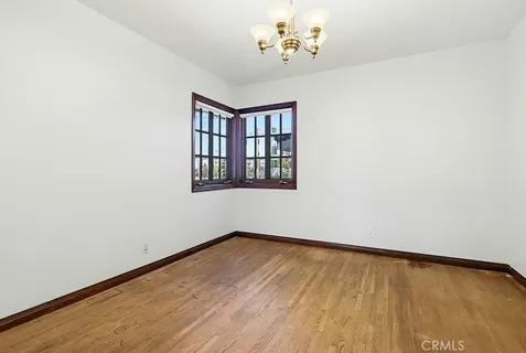 a view of a room with wooden floor and chandelier