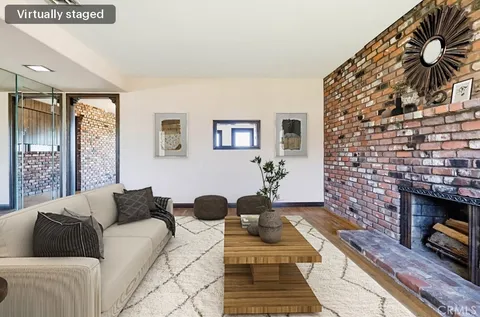 an empty room with wooden floor and a fireplace