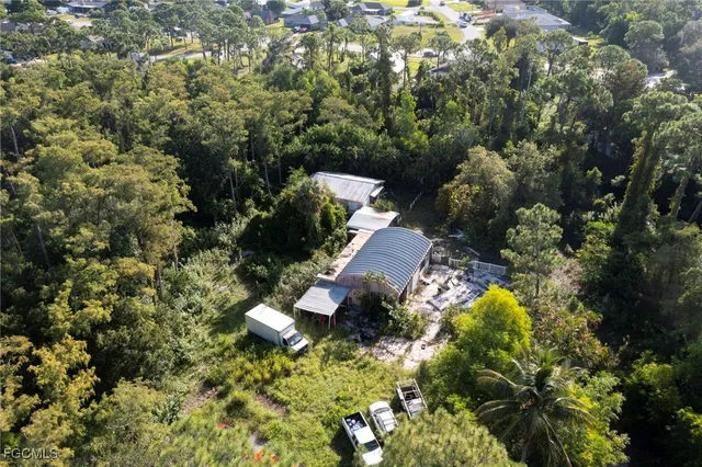 an aerial view of a house with a yard and trees