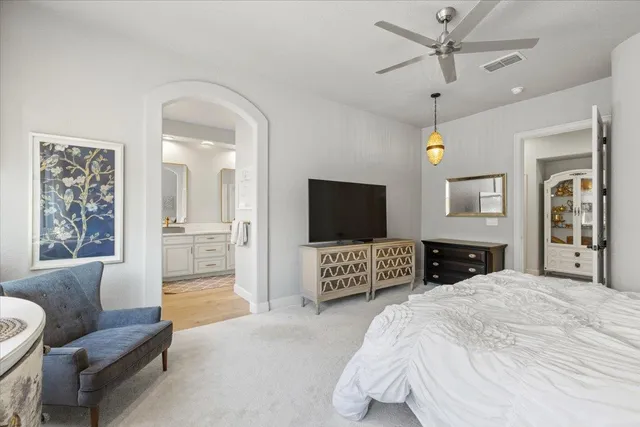 a spacious bedroom with a bed a couch and a flat screen television