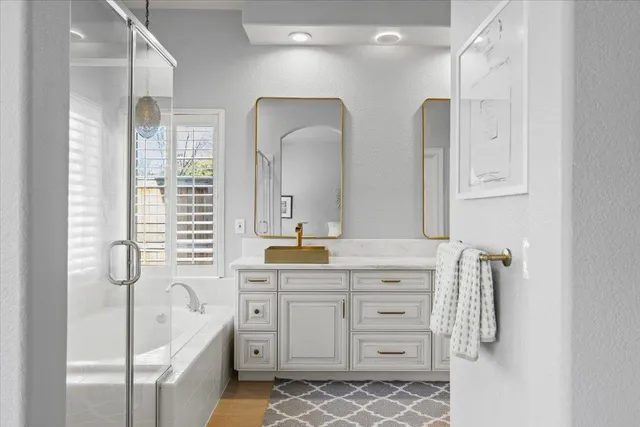 a spacious bathroom with a double vanity sink a mirror a bathtub and