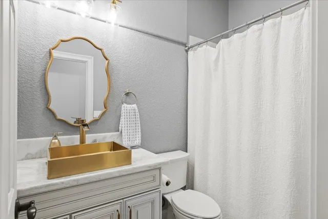 a bathroom with a toilet sink and mirror