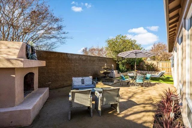 a view of a patio with a dining table and chairs with a fire pit