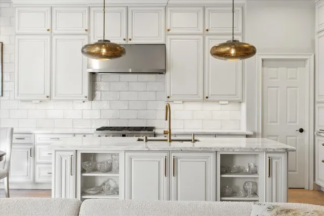 a kitchen with stainless steel appliances granite countertop a stove a sink and a white cabinets