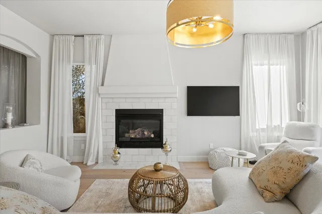 a living room with furniture a fireplace and a large window