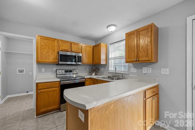 a kitchen with stainless steel appliances a stove a sink a microwave and cabinets