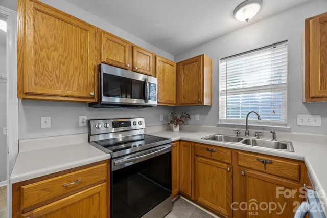 a kitchen with stainless steel appliances granite countertop a sink stove and microwave