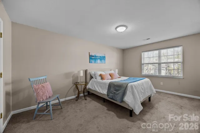 a bedroom with a bed chair and a window