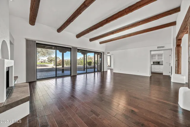 a view of an empty room window and wooden floor