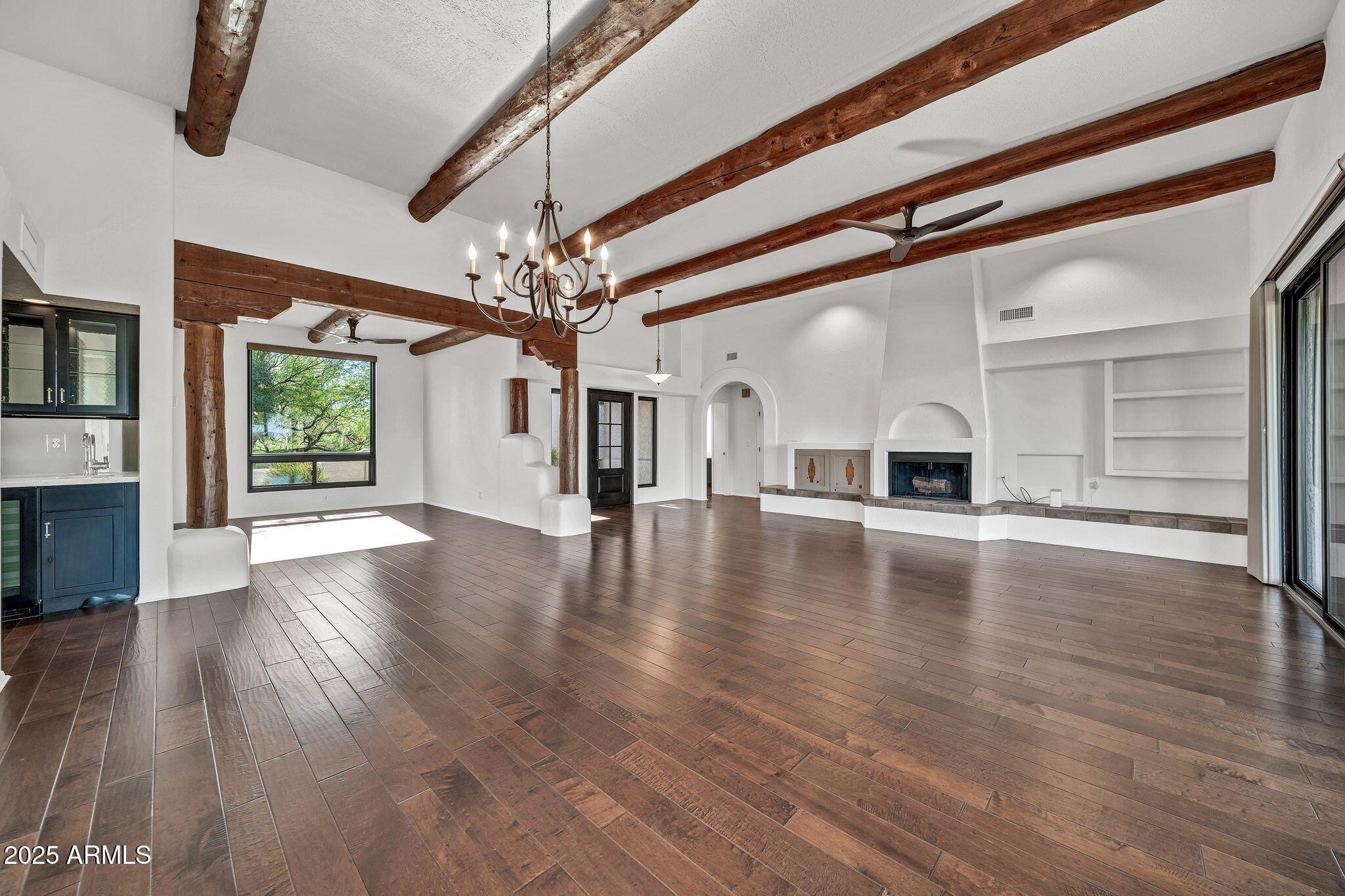 19002 East Alondra Way Rio Verde, AZ 85263 - Photo 20 of 62 a view of a livingroom with a flat screen tv wooden floor and a fireplace