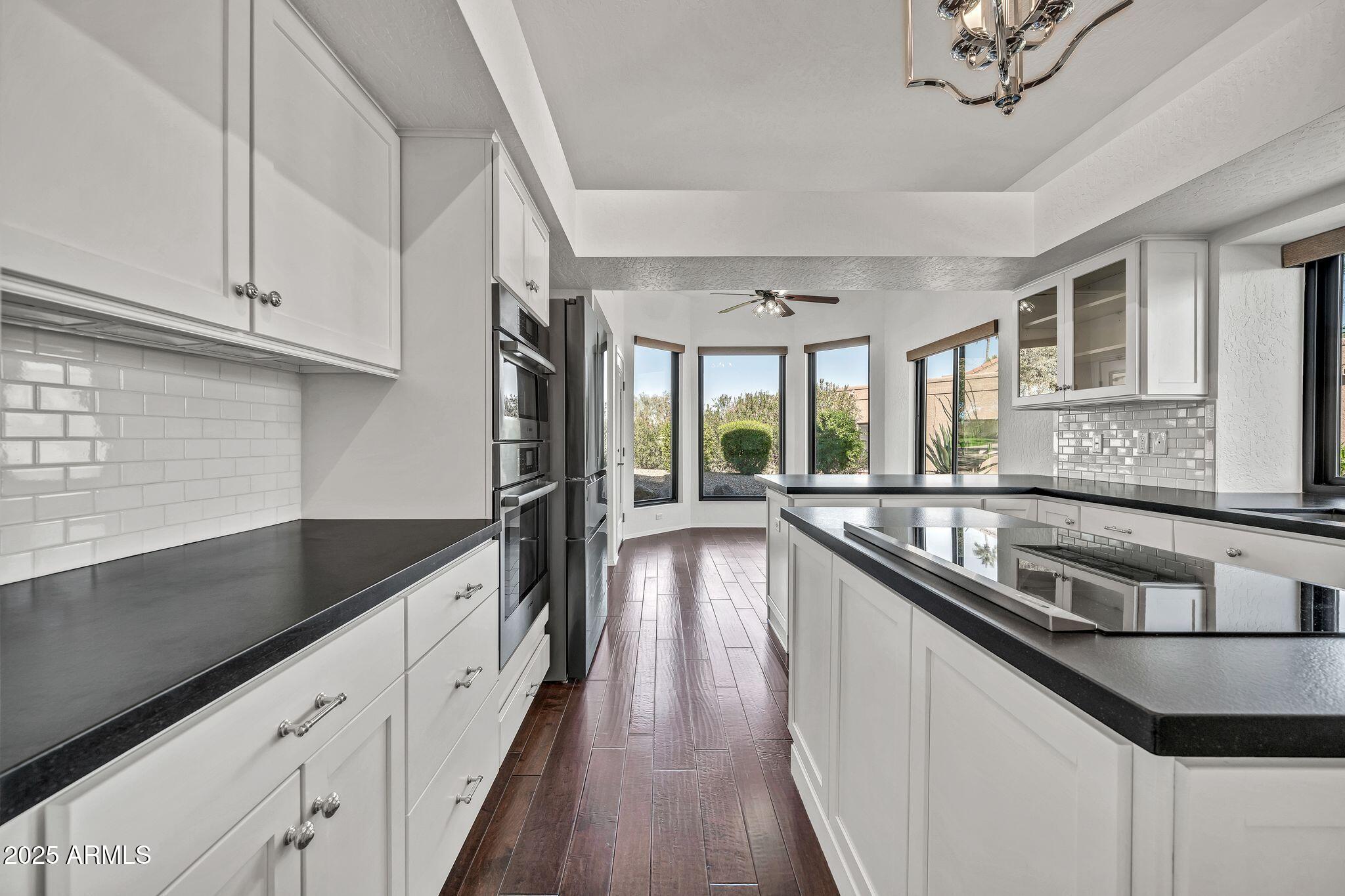 19002 East Alondra Way Rio Verde, AZ 85263 - Photo 27 of 62 a kitchen with stainless steel appliances granite countertop a sink a stove and a wooden floors