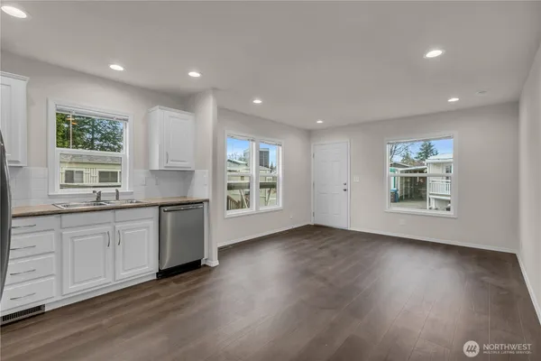 a view of a kitchen with window and wooden floor