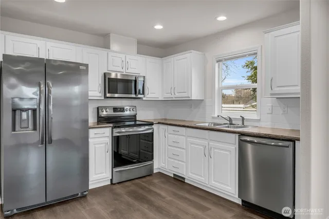 a kitchen with stainless steel appliances granite countertop a stove a sink and a refrigerator