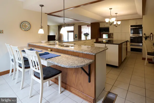 a kitchen with a sink a stove top oven cabinets and a window