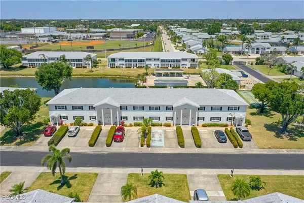 an aerial view of residential houses with outdoor space and lake view