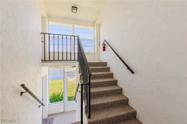 a view of staircase with railing and white walls
