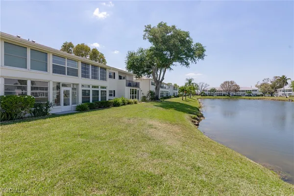 a view of a house with a yard and a lake view