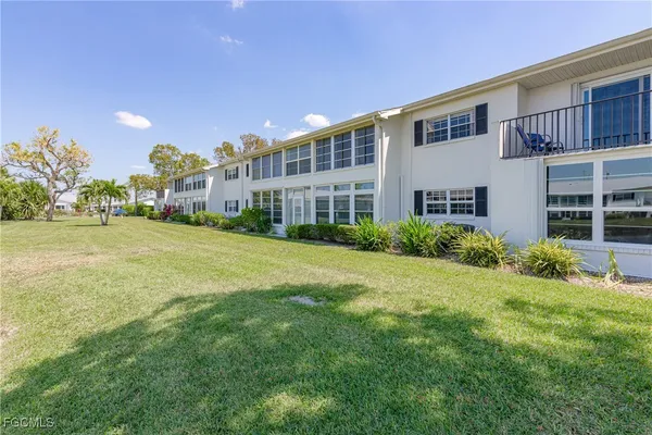 a view of a house with a big yard and large trees
