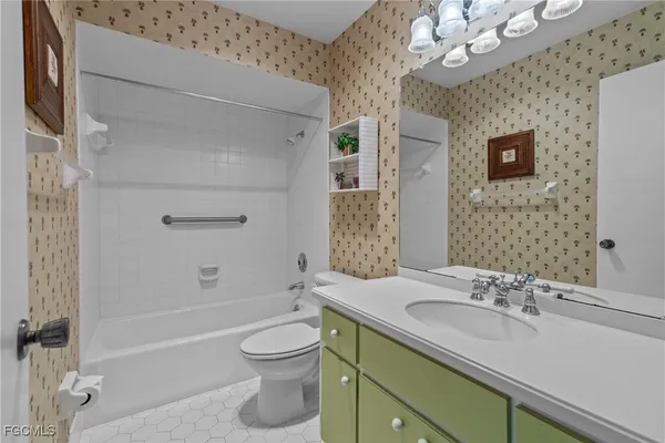 a bathroom with a sink a toilet a mirror and shower