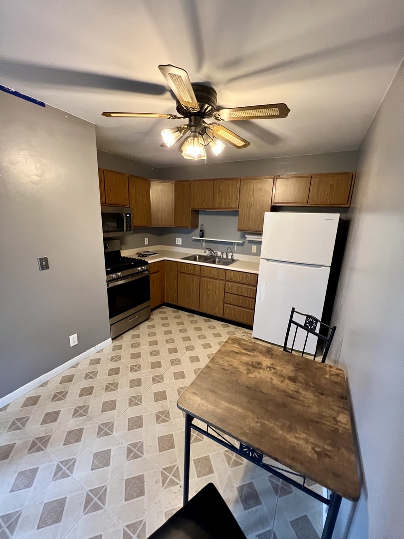 2350 Carnation Drive, Unit 4 Crest Hill, IL 60403 - Photo 5 of 19 a kitchen with a stove a sink a refrigerator dining table and chairs