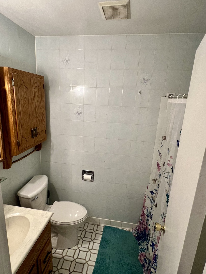 2350 Carnation Drive, Unit 4 Crest Hill, IL 60403 - Photo 9 of 19 a white toilet sitting next to a shower curtain