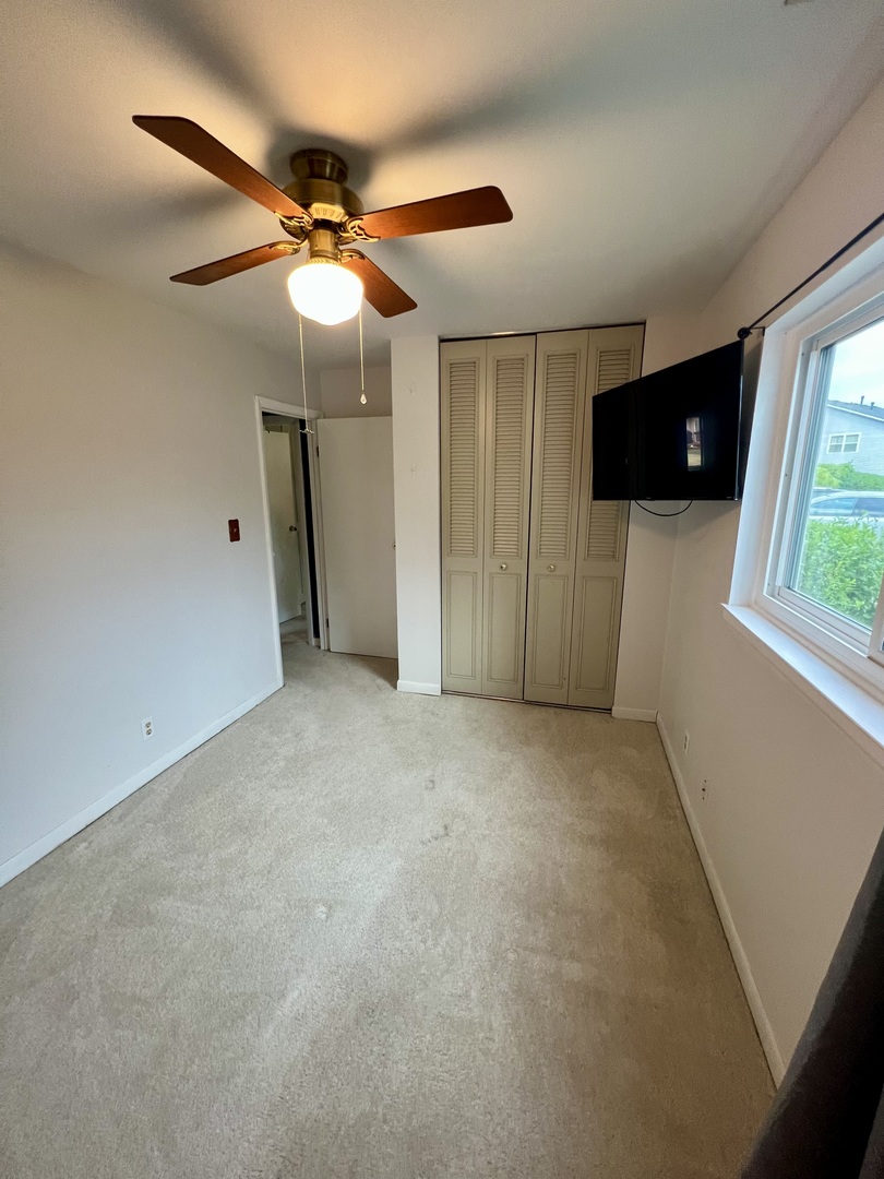 2350 Carnation Drive, Unit 4 Crest Hill, IL 60403 - Photo 10 of 19 a view of a livingroom with a ceiling fan and window