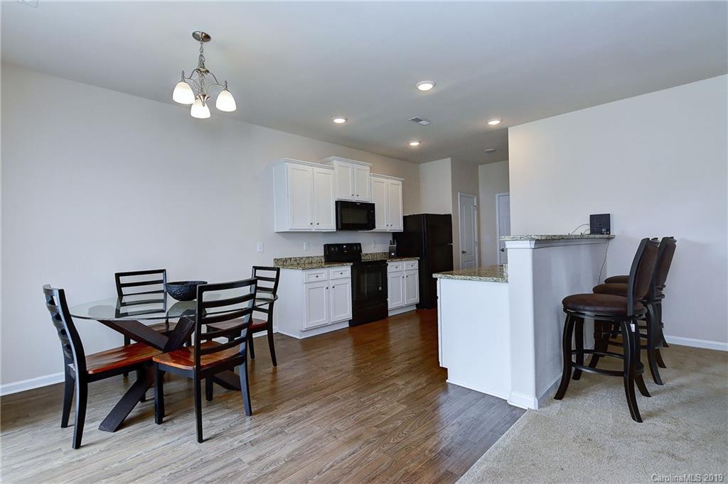 9537 Weikert Road Charlotte, NC 28215 - Photo 12 of 31 a view of a dining room with furniture and wooden floor