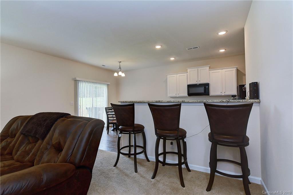 9537 Weikert Road Charlotte, NC 28215 - Photo 14 of 31 a living room with furniture a two chairs and a refrigerator