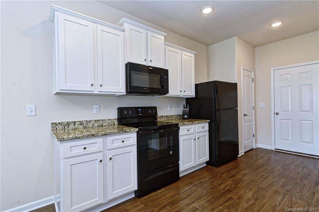 9537 Weikert Road Charlotte, NC 28215 - Photo 15 of 31 a kitchen with white cabinets and stainless steel appliances