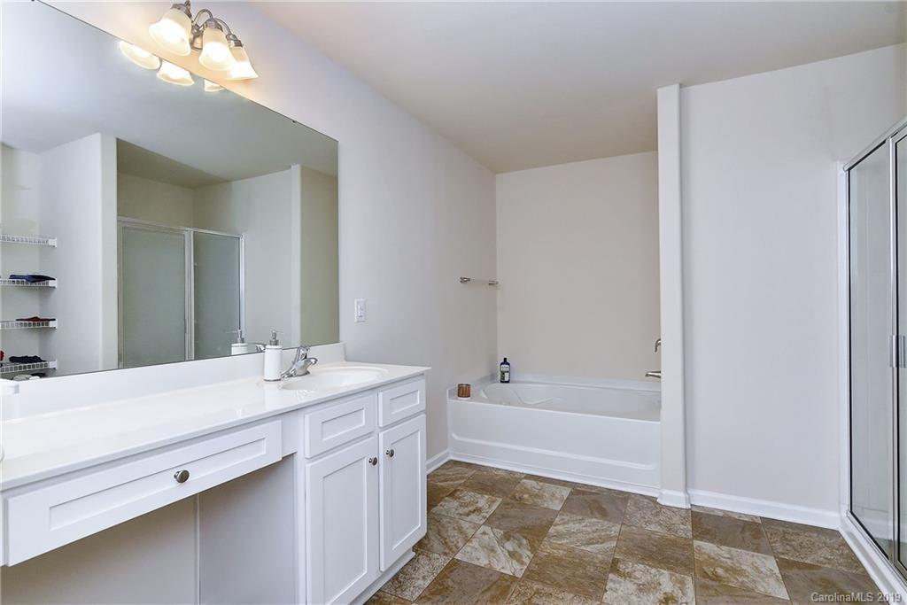 9537 Weikert Road Charlotte, NC 28215 - Photo 21 of 31 a bathroom with a sink a mirror and a bathtub