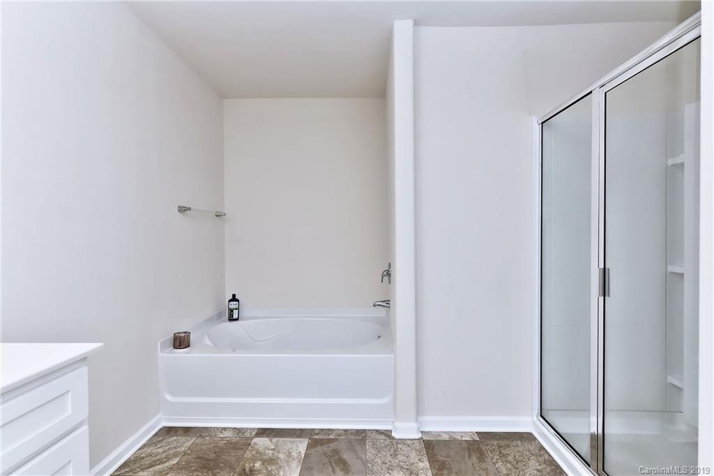 9537 Weikert Road Charlotte, NC 28215 - Photo 23 of 31 a bathroom with a bathtub and a shower
