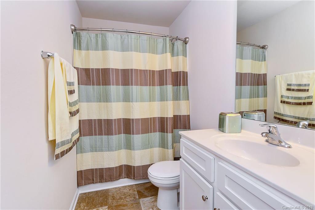 9537 Weikert Road Charlotte, NC 28215 - Photo 28 of 31 a bathroom with a sink a toilet a mirror and shower curtain