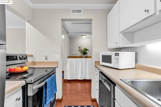 a kitchen with stainless steel appliances granite countertop a stove a sink and a microwave