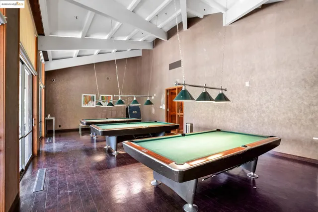 a living room with table chairs and wooden floor